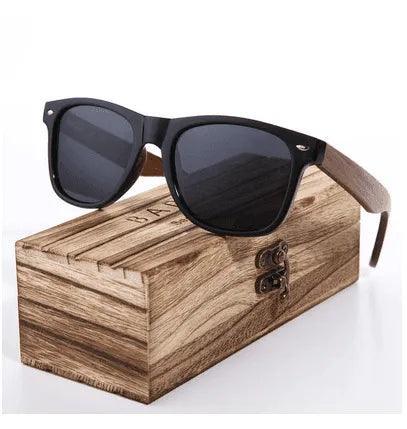 Stylish black-framed sunglasses with wooden arms resting on a rustic wood box, perfect for fashion or daily wear.