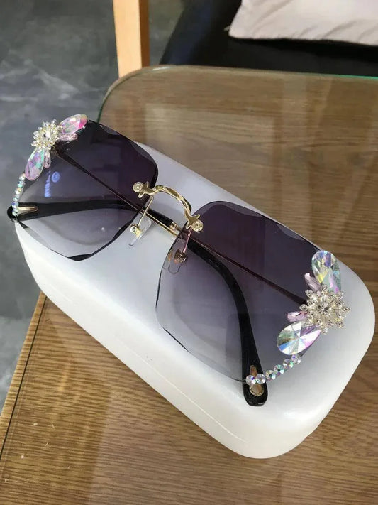 Stylish rhinestone-embellished sunglasses with gradient lenses, displayed on a white case for fashion or daily wear.