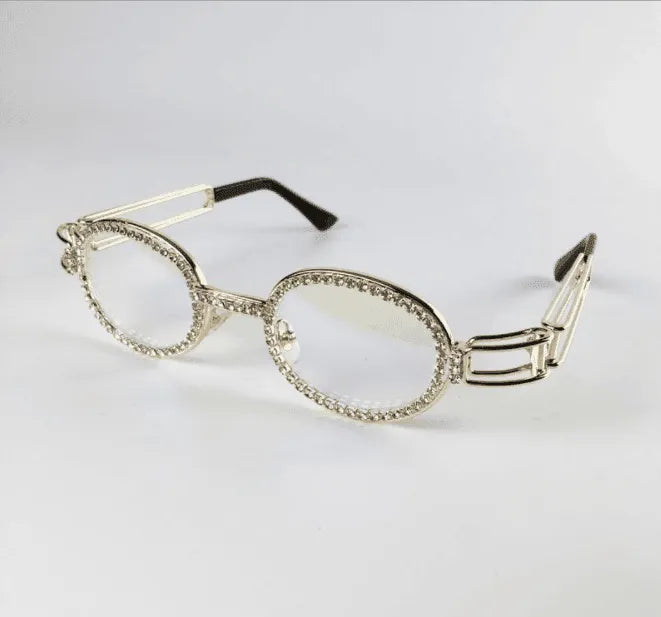 Oval clear lens sunglasses with silver diamond-studded frame and black temple tips