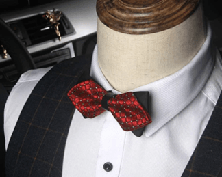Red patterned butterfly bow tie worn with white dress shirt and dark vest on mannequin
