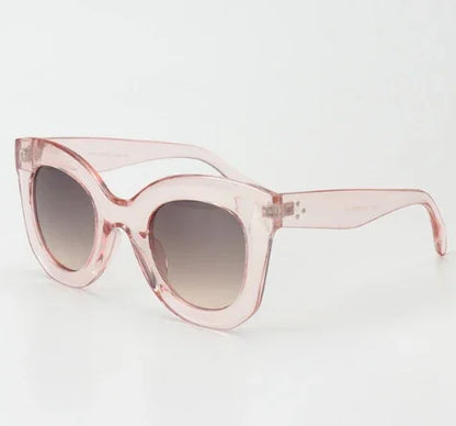 Pink translucent cat-eye sunglasses with gradient dark lenses on white background