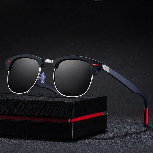 Black and silver sunglasses with dark lenses resting on a textured black box with a red stripe