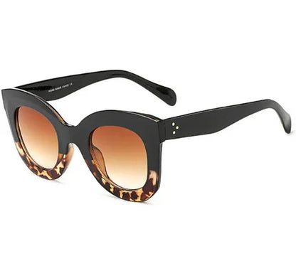 Black oversized cat-eye sunglasses with tortoiseshell accents and gradient brown lenses