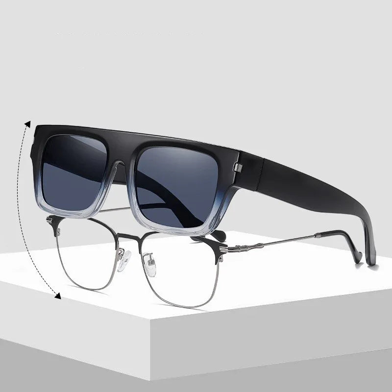 Convertible glasses with clear lower frame and dark tinted clip-on sunglasses, displayed on white surface