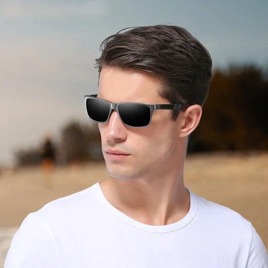 Young man wearing black rectangular sunglasses and white t-shirt outdoors with blurred natural background