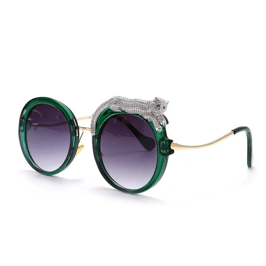 Round green sunglasses with dark gradient lenses and a silver panther embellishment on the frame