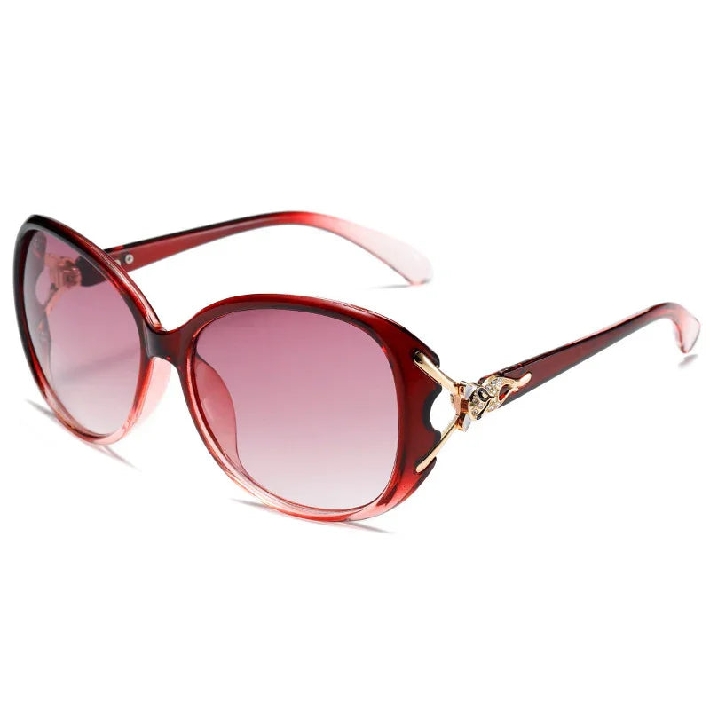 Stylish red gradient lens sunglasses with gold decorative accents on the temples