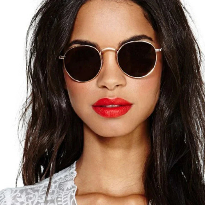 Close-up of woman with long dark hair wearing round black sunglasses and bright red lipstick