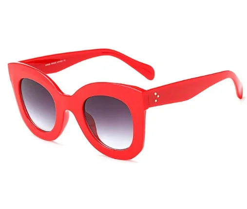 Bold red oversized cat-eye sunglasses with gradient dark lenses and thick frames