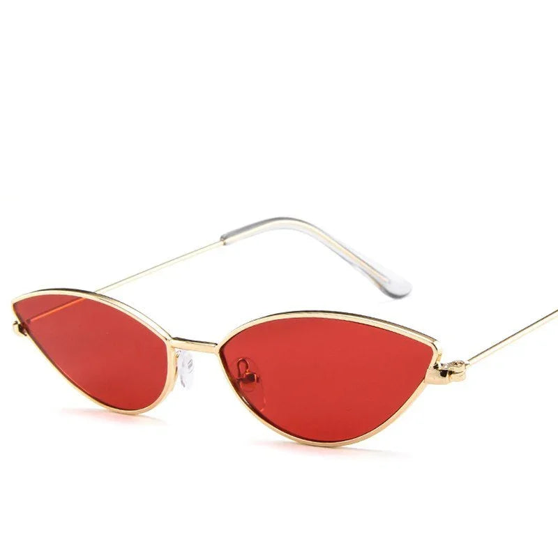 Cat-eye sunglasses with thin gold frames and red tinted lenses on white background