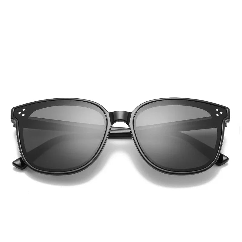Black plastic frame sunglasses with wide square tinted lenses and silver rivet accents