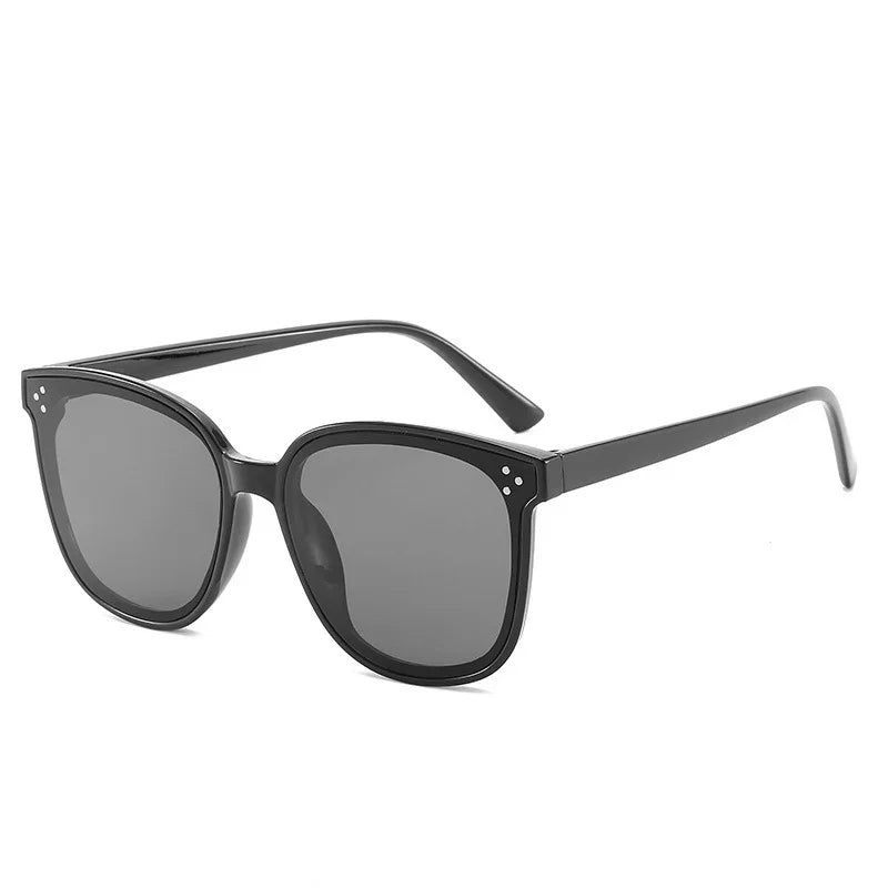 black square frame sunglasses with dark lenses and small decorative dots on corners