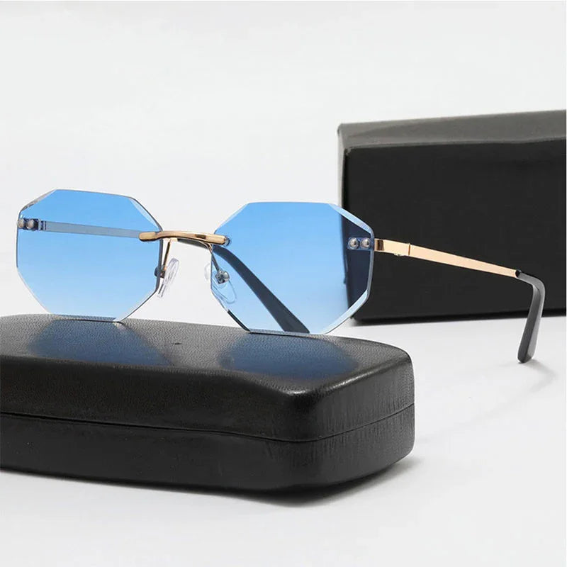Octagonal blue lens sunglasses with gold metal frame resting on black case and box