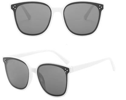 White frame sunglasses with dark gray lenses and black corner accents with three small dots