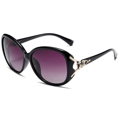 Black oversized sunglasses with gradient purple lenses and decorative gold accents on temples