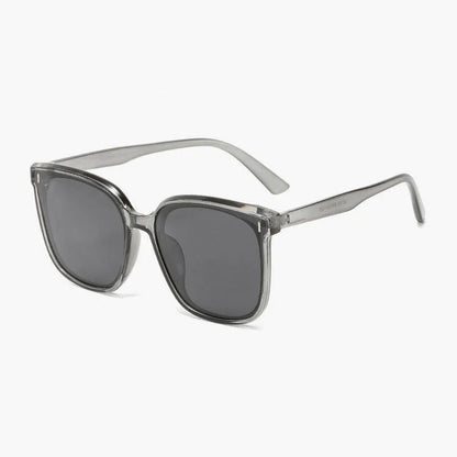 Transparent gray frame sunglasses with dark tinted lenses on white background