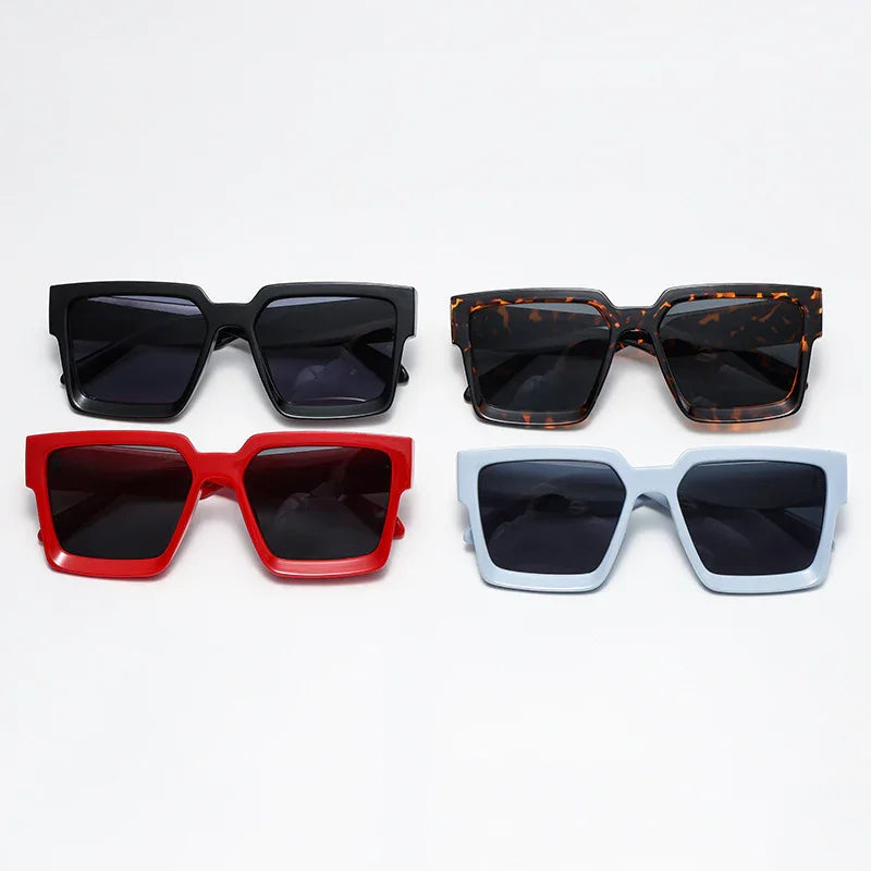 Four pairs of oversized square sunglasses in black, tortoiseshell, red, and light blue frames with dark lenses