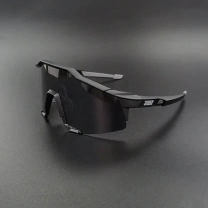 Black wraparound sports sunglasses with dark lenses on a matte black surface