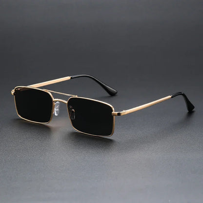 Rectangular black-lens sunglasses with gold metal frame and black temple tips on dark background