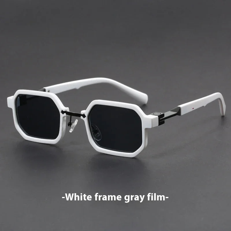 White-framed geometric sunglasses with dark gray lenses on a black surface