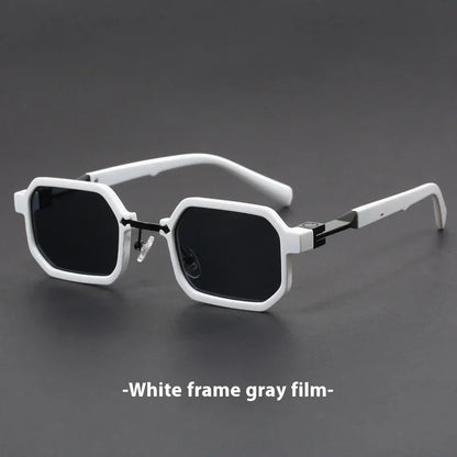 White-framed geometric sunglasses with dark gray lenses on a black surface