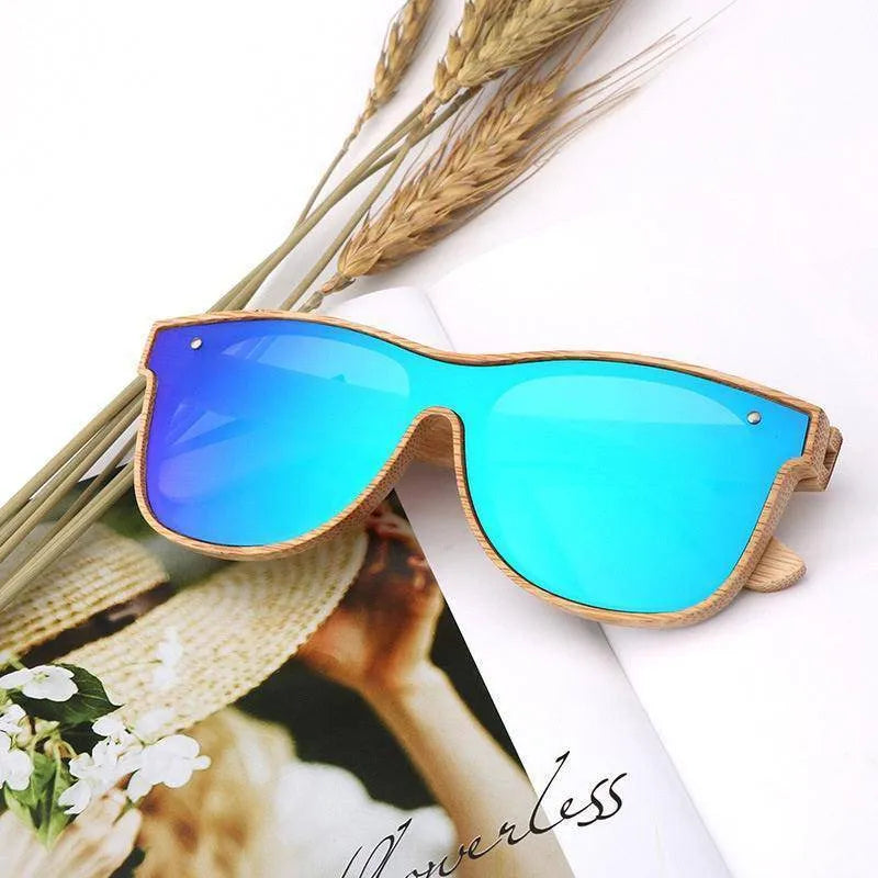 blue mirrored polarized sunglasses with wooden bamboo frame on magazine page with stalks of wheat