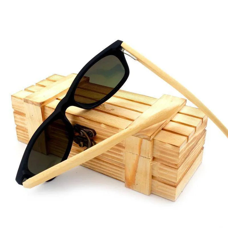 Black framed sunglasses with wooden arms resting on a wooden box with metal latch