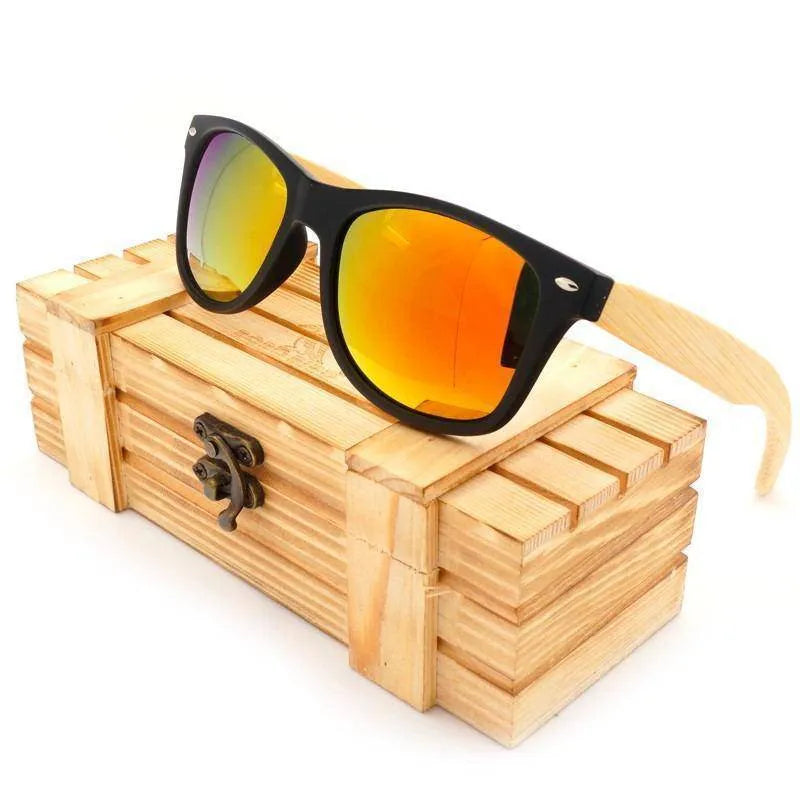 Black frame sunglasses with orange reflective lenses and wooden arms resting on a wooden box with latch