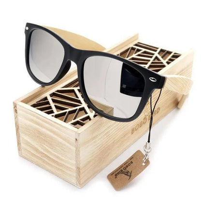 Black framed sunglasses with wooden temples resting on a decorative wooden box