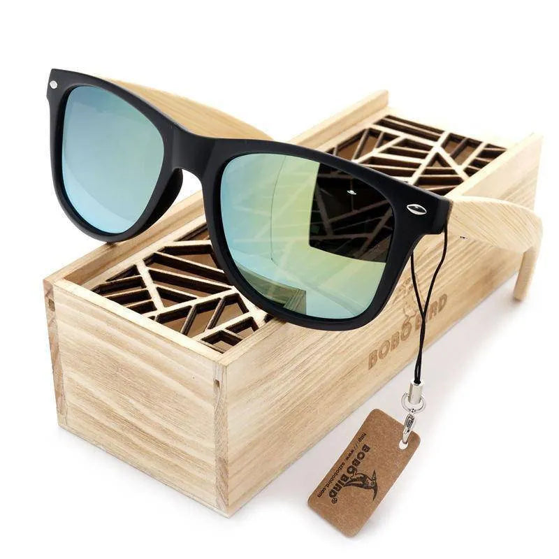 Stylish sunglasses with black frame and blue mirrored lenses on wooden box with geometric pattern