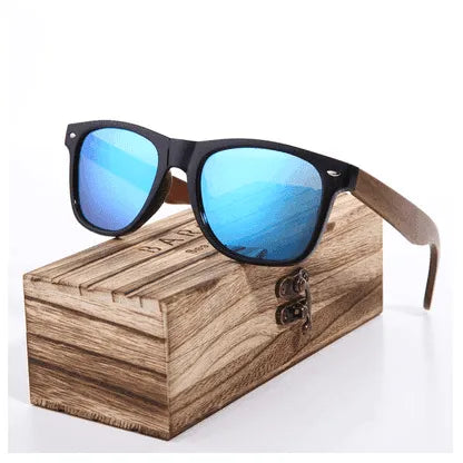 Glossy black frame sunglasses with blue polarized lenses and wooden arms on a wooden box