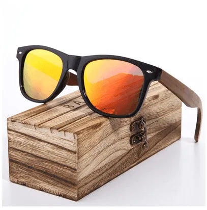 Glossy black frame sunglasses with orange mirrored polarized lenses and wooden temple arms on wooden display box