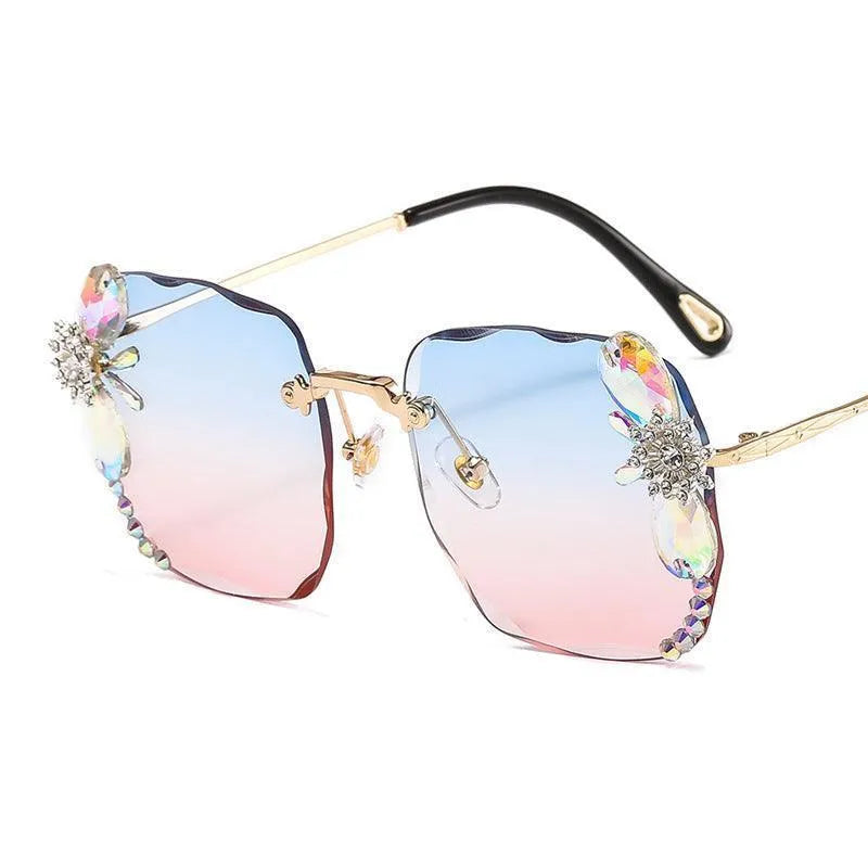 Grey frameless sunglasses with rhinestone accents and gradient pink to blue lenses