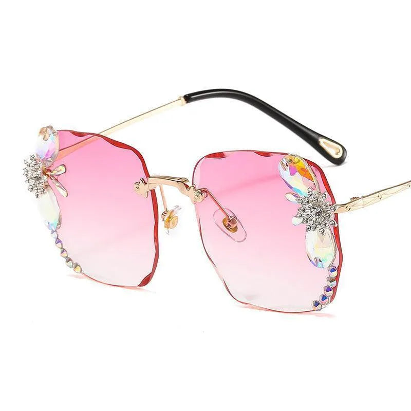 Pink gradient frameless rhinestone sunglasses with gold temples and decorative gems