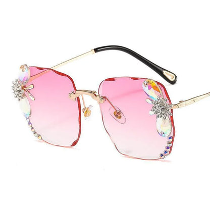 Pink gradient frameless rhinestone sunglasses with gold temples and decorative gems