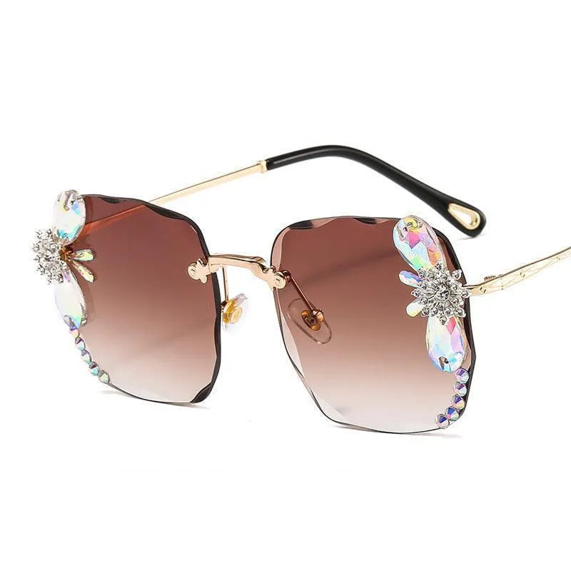 Grey frameless sunglasses with rhinestone and gradient lenses, gold arms, crystal accents