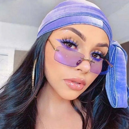 Close-up of woman wearing square rimless purple sunglasses and matching purple headscarf with long dark hair