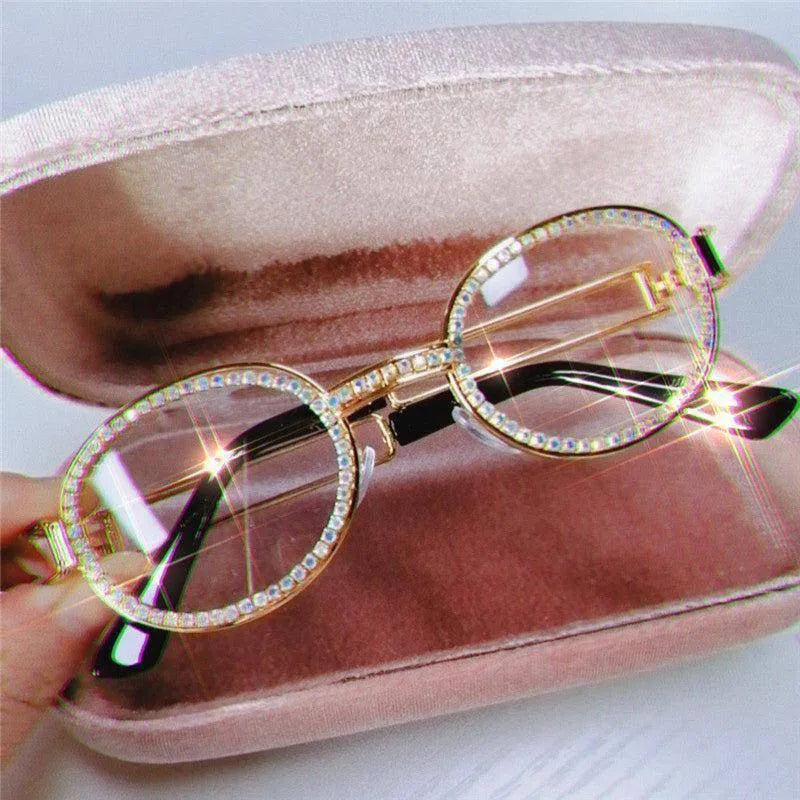Round vintage eyeglasses with rhinestone-studded gold frames in a pink velvet case
