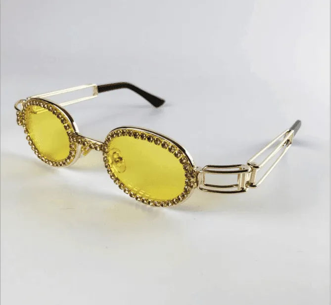 Oval yellow tinted sunglasses with gold metal frame and rhinestone detailing