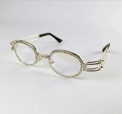 Oval clear lens sunglasses with silver diamond-studded frame and black temple tips